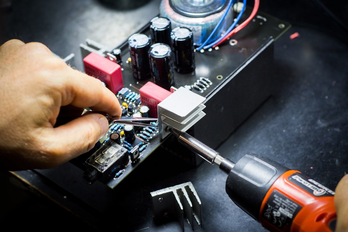 Hands assembling an electronic circuit board on a workbench